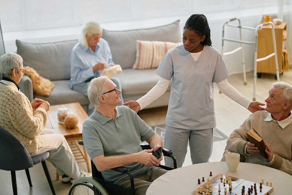 Adult children and an older parent talking seriously at a kitchen table, papers and coffee cups visible.