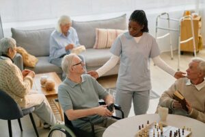 Older adult and family member reviewing Medicare and assisted living paperwork at a kitchen table.